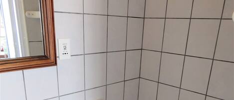 Et lille badeværelse med toilet, vask og spejl.