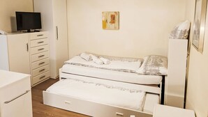 A compact bedroom with a bed, a television on a cabinet, and a painting on the wall. - Studio Turmalin by Interhome (Leukerbad)
