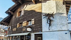 A wooden building with a clinic sign, a mailbox, and a wooden bench outside. - Studio Turmalin by Interhome (Leukerbad)