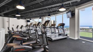 A gym with multiple cardio machines, large windows, and a view of the ocean. - 2BR Resort-Style Condo with Lakefront Views & Mini Golf (Panama City Beach)
