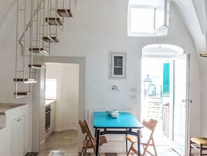 A kitchen with a blue table, chairs, and a staircase. - Via Garibaldi by Interhome (Locorotondo)