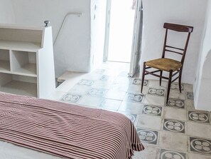 Ein Zimmer mit einem Bett, einem Sessel und einer Treppe.