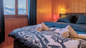A wooden cabin bedroom with a bed, pillows, and a nightstand. - Mayens du Rudet by Interhome (Erde)