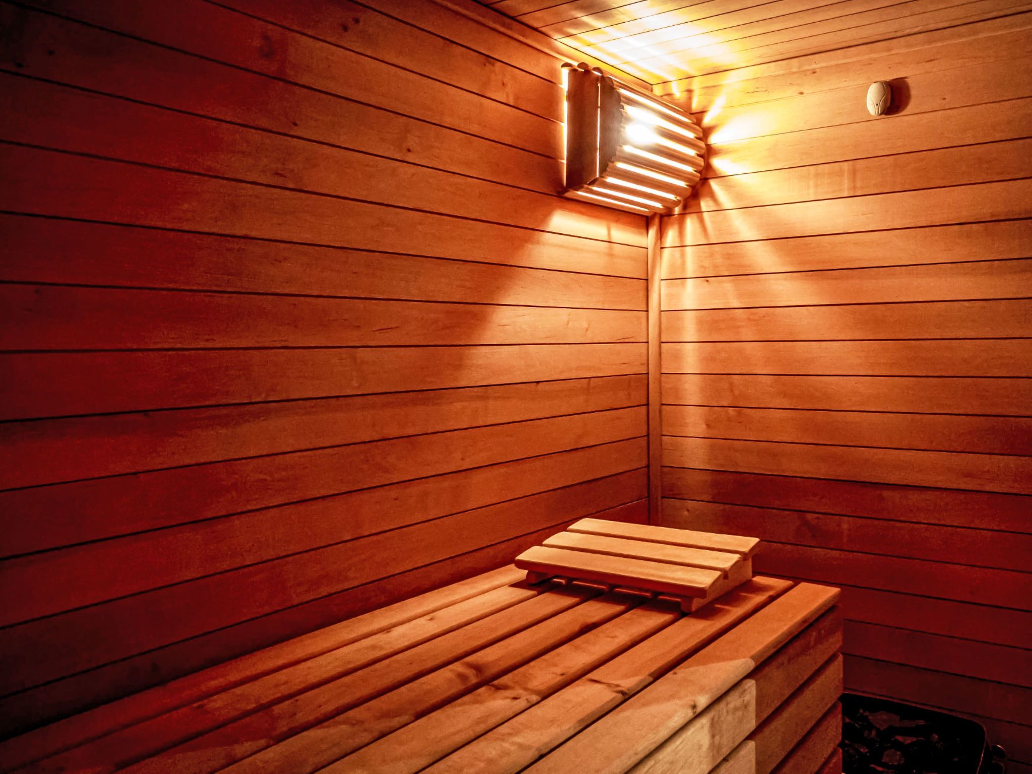 A sauna with wooden benches and a slanted ceiling.