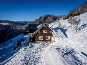 A wooden chalet with a sloped roof, a balcony, and a view of a snow-covered valley. - Na Stráni by Interhome (Jablonec nad Jizerou)