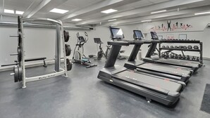 Een fitnessruimte met loopbanden, krachttoestellen en cardioapparatuur.