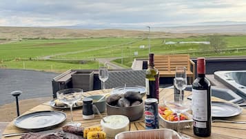 A dining table with various dishes, drinks, and a scenic view.