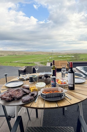 A dining table with various dishes, drinks, and a scenic view. - Valey Countryside Escape (Hvammstangi)
