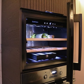 A minibar with a digital display, a wine bottle, and a bottle of water. - Valey Countryside Escape (Hvammstangi)