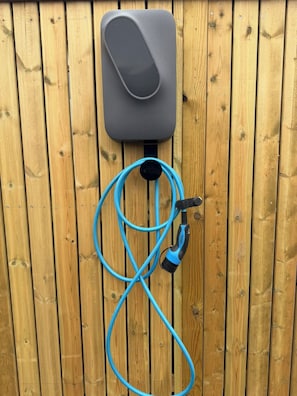 A wooden fence with a gray outdoor unit and a blue hose. - Valey Countryside Escape (Hvammstangi)