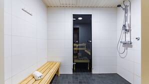 Et moderne badeværelse med bænk, bruser og spejl.