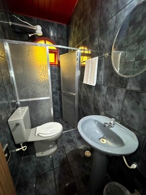 Chuveiro, toalhas de banho, sabonete, papel higiênico