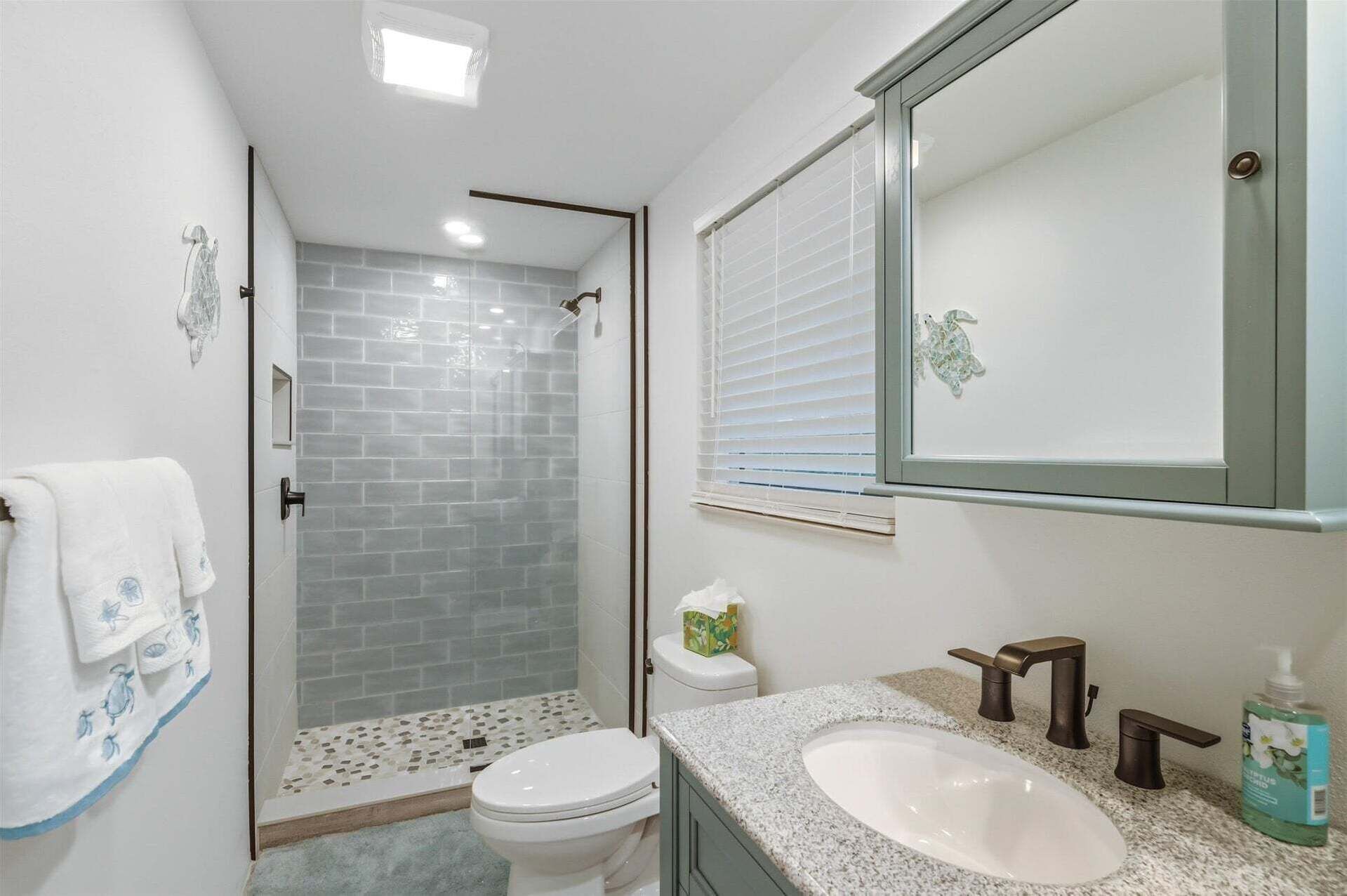 A bathroom with a shower, toilet, and sink.