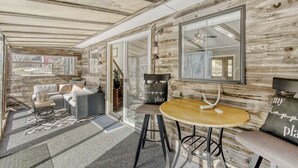 A cozy, rustic interior with a wooden wall, a round table, and a sofa. - Black Hawk Getaway W/ Hot Tub 3 Bedroom Cabin (Black Hawk)