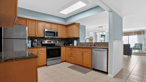 A modern kitchen with wooden cabinets, stainless steel appliances, and a skylight. - Ocean One 213 - Second Floor Oceanfront 3BR Condo (Hilton Head Island)