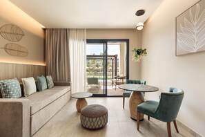 Una sala de estar moderna con sofá, reposapiés, mesa redonda y sillas.