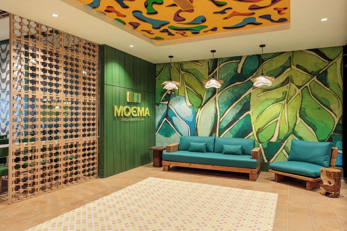 Un intérieur moderne avec un mur vert, un canapé et un plafond décoratif.