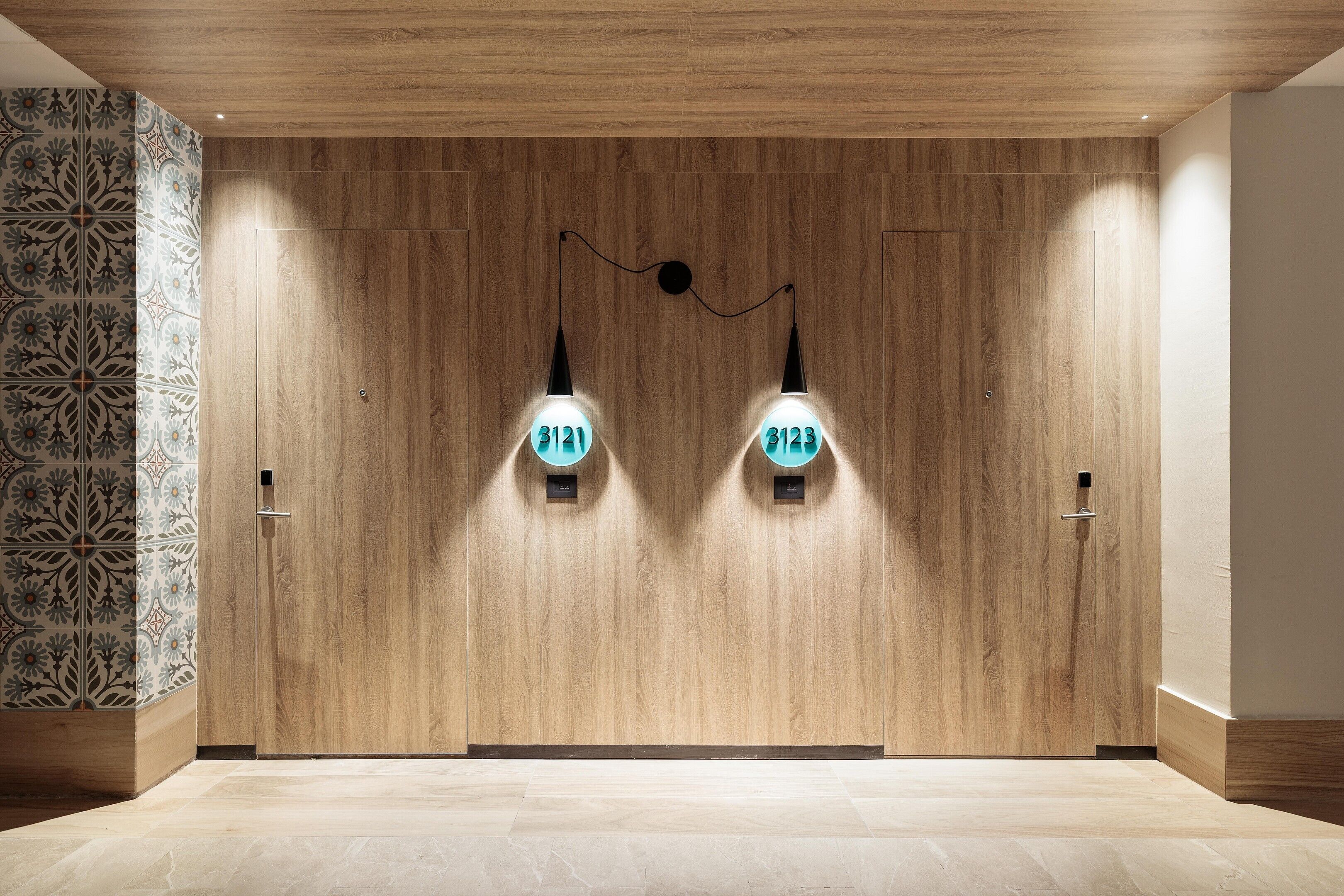 A wooden wall with two light fixtures and a patterned wall to the left.