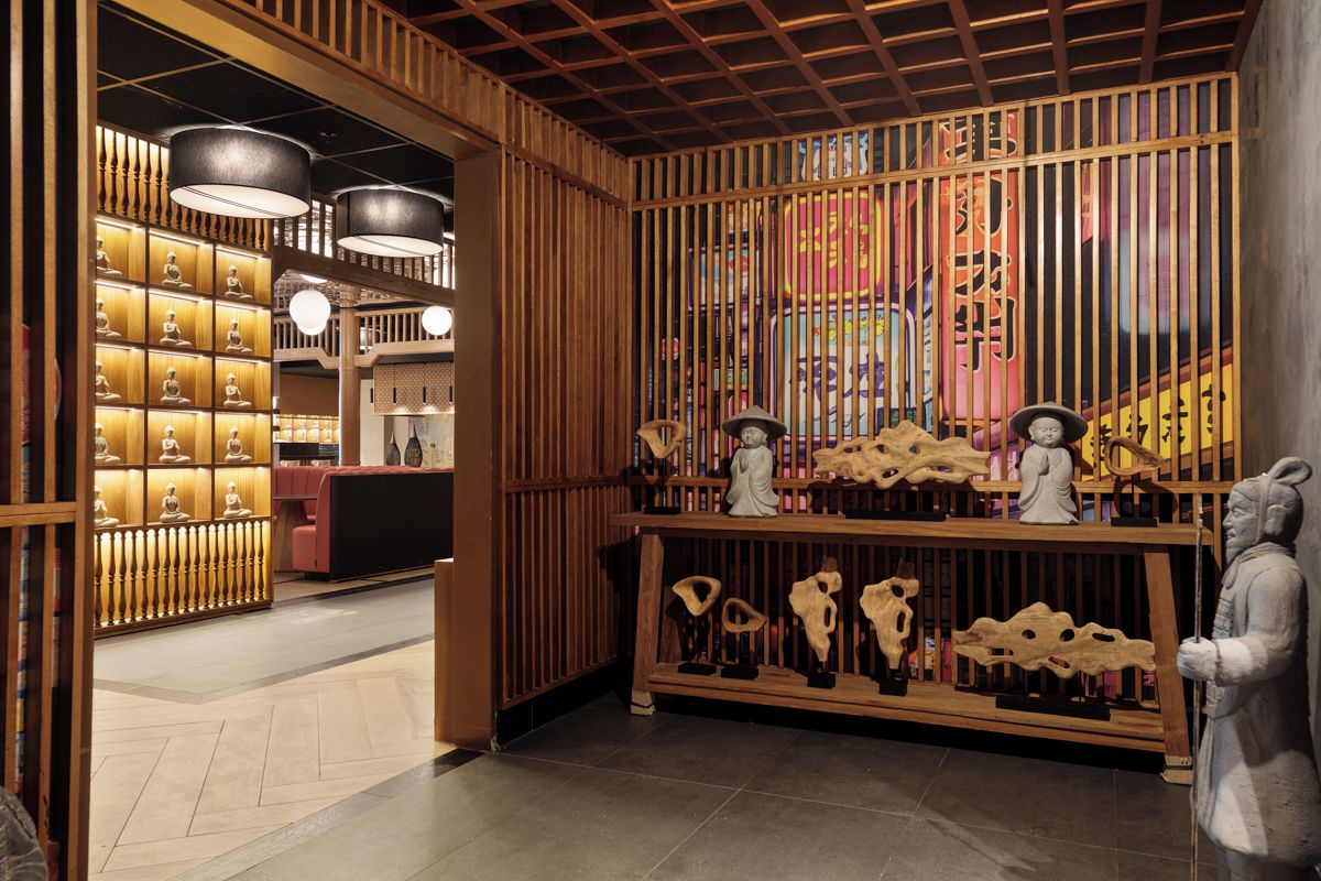 Un'accogliente ambientazione tradizionale con pareti divisorie in legno, una reception e diversi manufatti culturali.