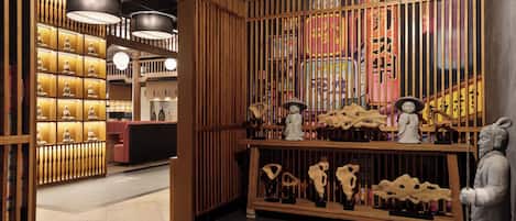 A traditional interior with wooden partitions, a reception desk, and various cultural artifacts.