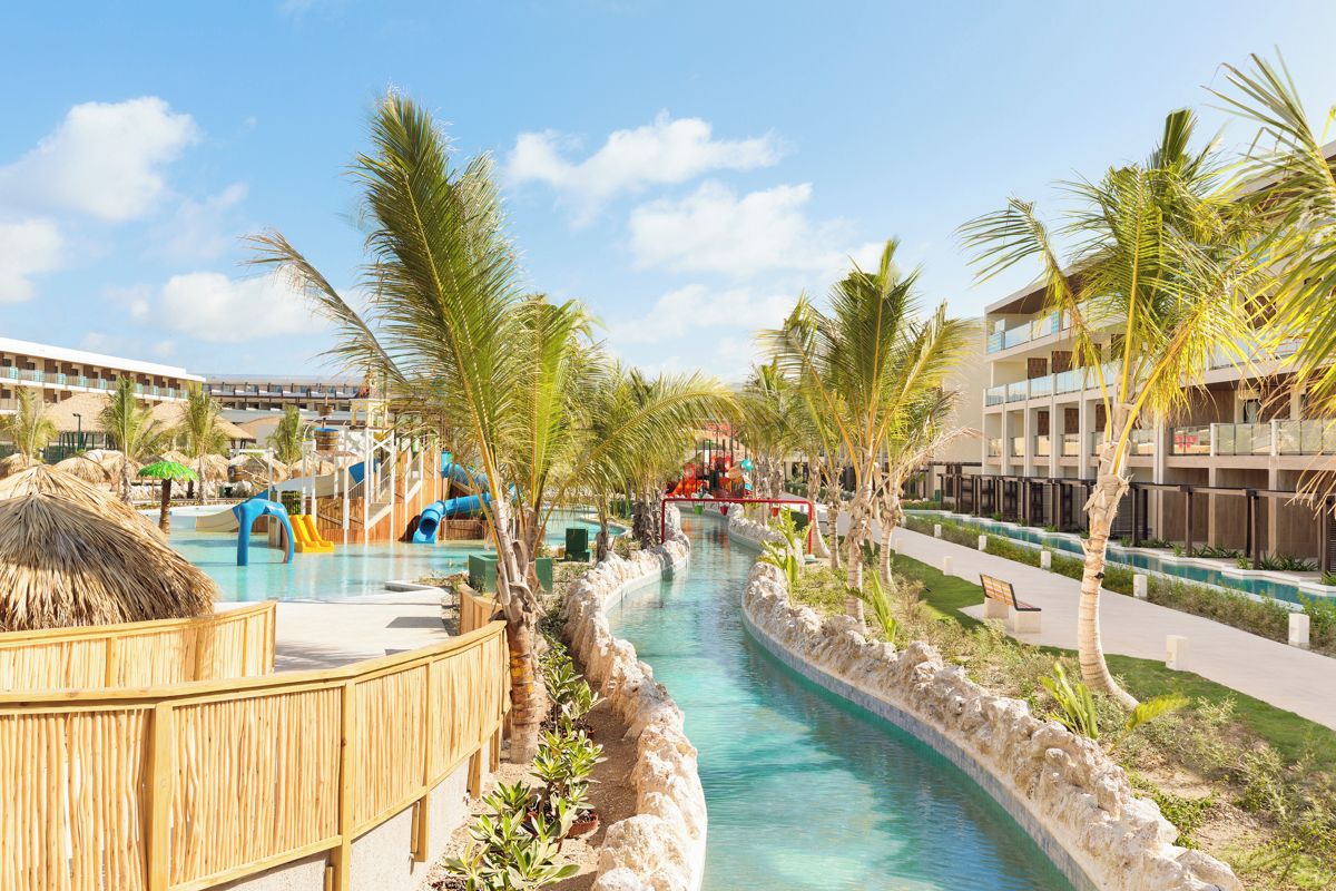 Ein Resort mit Swimmingpool, Palmen und einer Wasserrutsche.