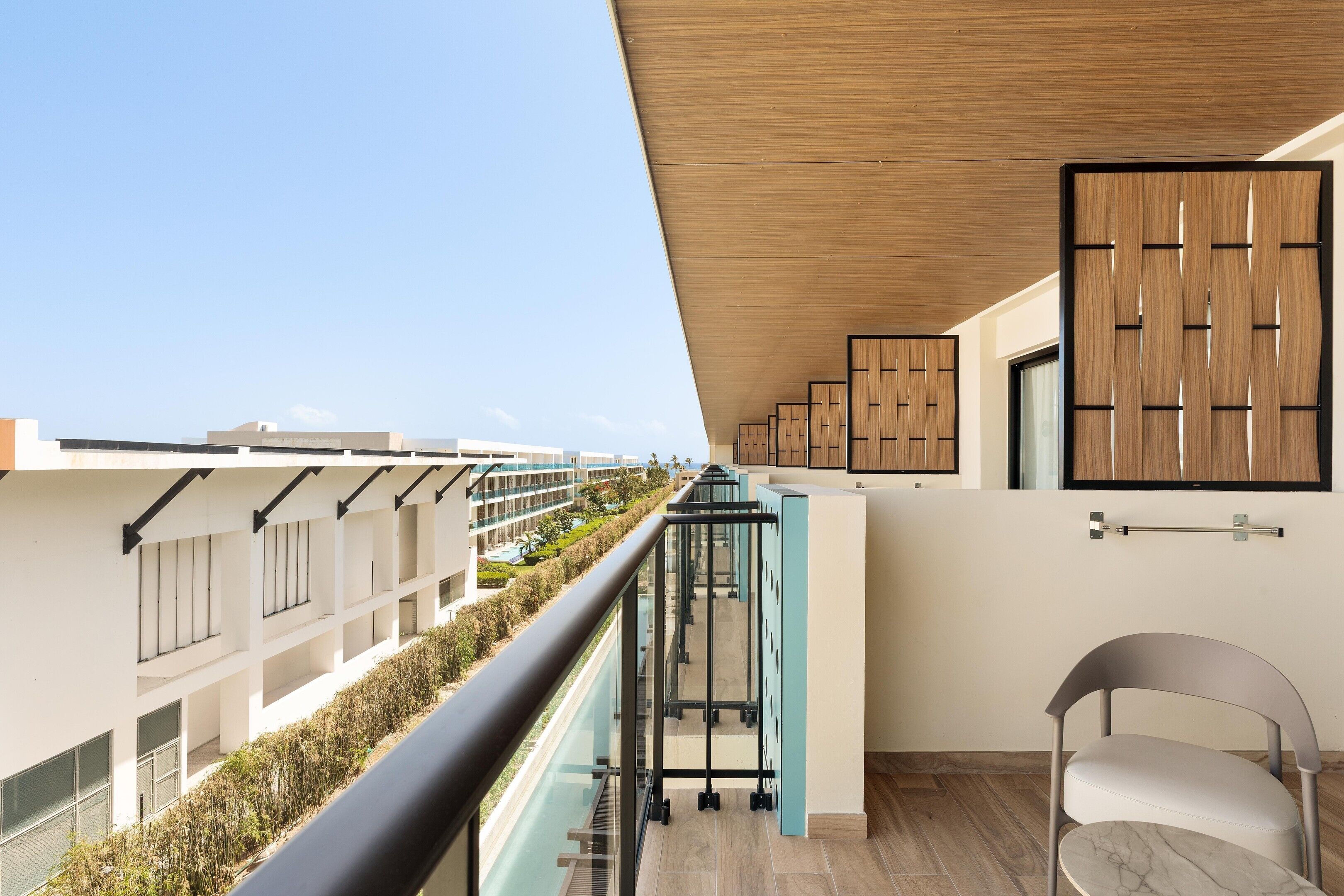 Een modern appartement met balkon, uitzicht op andere gebouwen en een houten plafond.