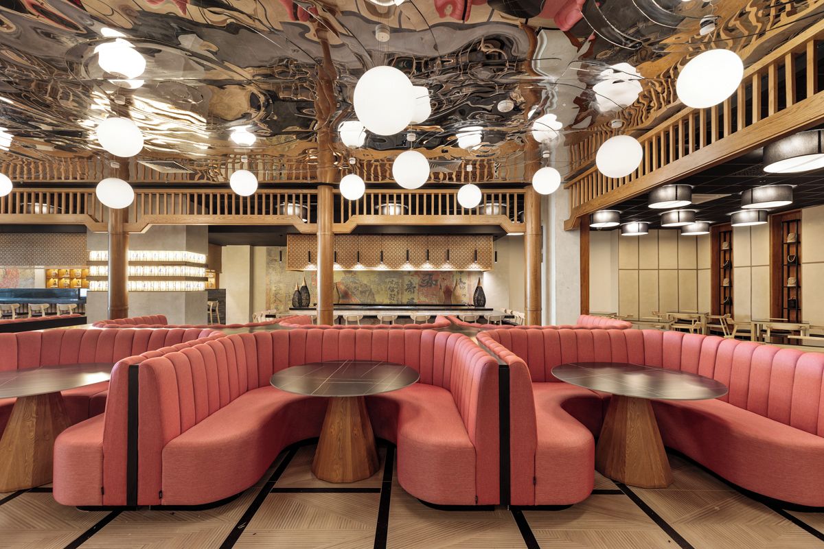 Un restaurant avec des banquettes rouges, des tables rondes et un plafond orné de fresques artistiques.