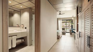 Un baño moderno con un espejo grande, muebles de madera y suelo de baldosas.