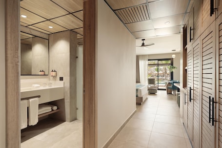 A modern bathroom with a large mirror, wooden cabinets, and a tiled floor.