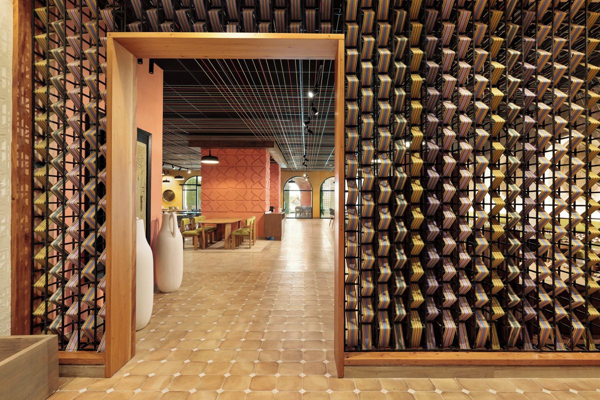 Une cave à vin avec un mur décor é de motifs et un sol carrelé.