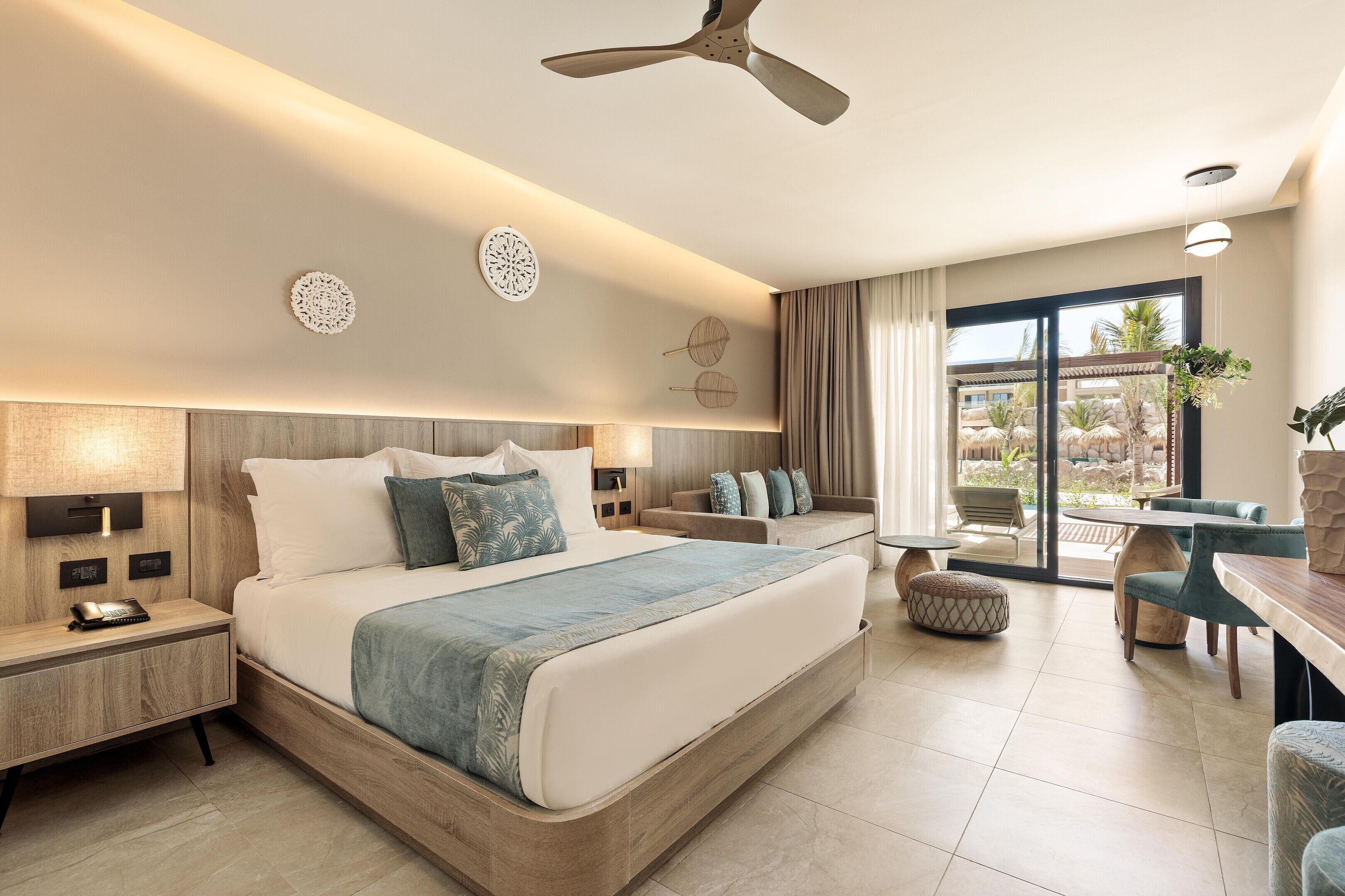 Une chambre d’hôtel moderne, dotée d’un grand lit, d’un bureau et d’un coin repas.