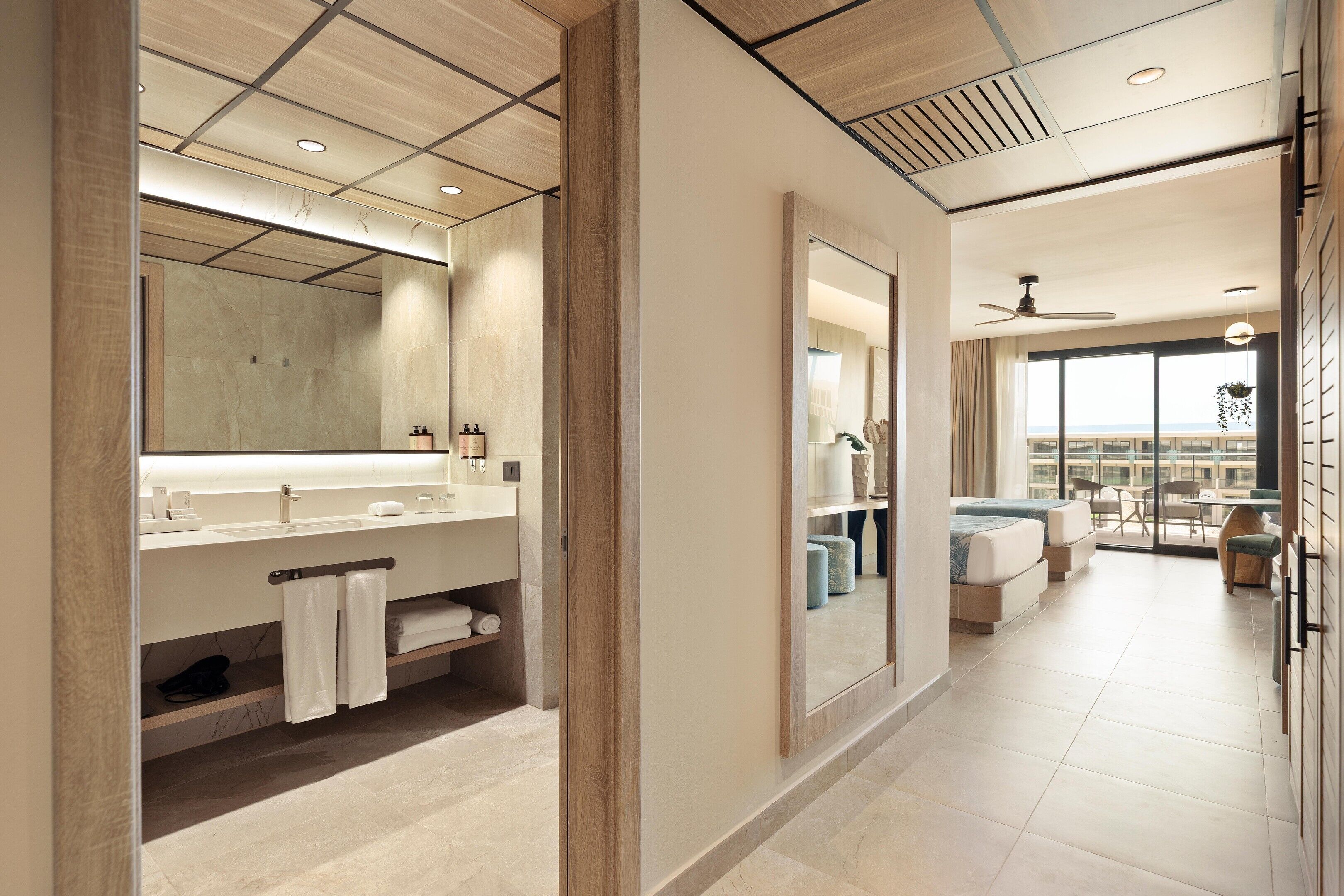 A modern bathroom with a large mirror, dual sinks, and a towel rack.