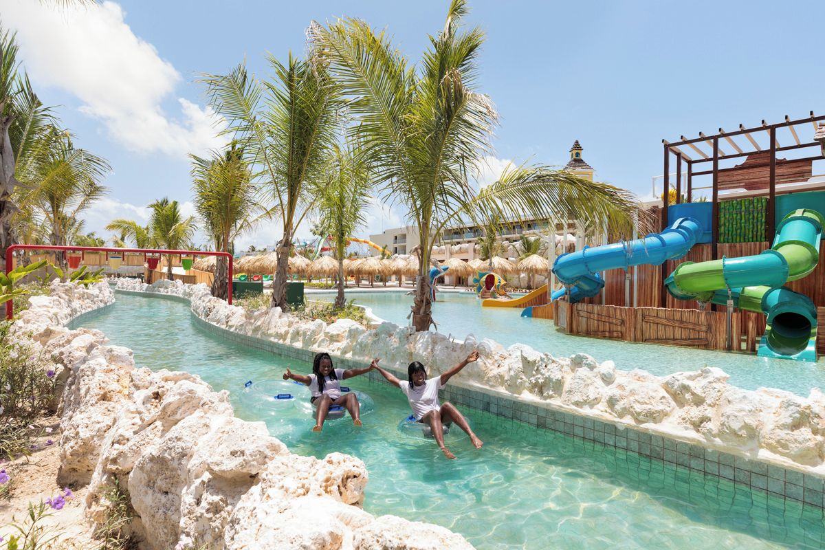 Ein Poolbereich mit Wasserrutschen und Palmen.