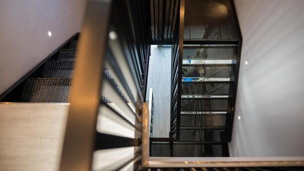 A modern interior with a metal staircase and a view of a room with a white wall and a window. - GREY HOUSE SRLS (Latina)