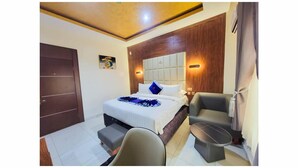 Une chambre d’hôtel avec un lit, un bureau, une chaise et une petite table.
