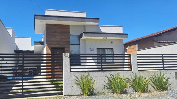 A modern two-story house with a gated entrance, a pool, and a small garden area. - Prehenn Beach House with Pool (Itapoá)