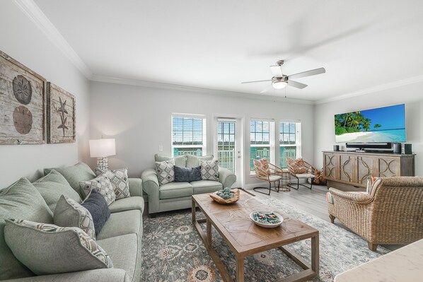 A living room with a sofa, coffee table, and a television. - Beachside Townhome | Pool, Gulf Views & Beach Path (Corpus Christi)
