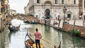A canal with gondolas, a bridge, and a historic building with ornate architecture. - Ca' Petunia Art Apartment R&R (Venecia)