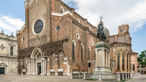 A historic building with a large central dome, arched windows, and a statue of a figure on horseback. - Ca' Petunia Art Apartment R&R (Venecia)