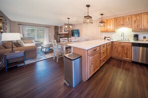 A modern kitchen with wooden cabinets, a stainless steel dishwasher, and a central island. - Beaver Village Unit #0922R Inviting newly renovated with solid wood furnishings (Winter Park)