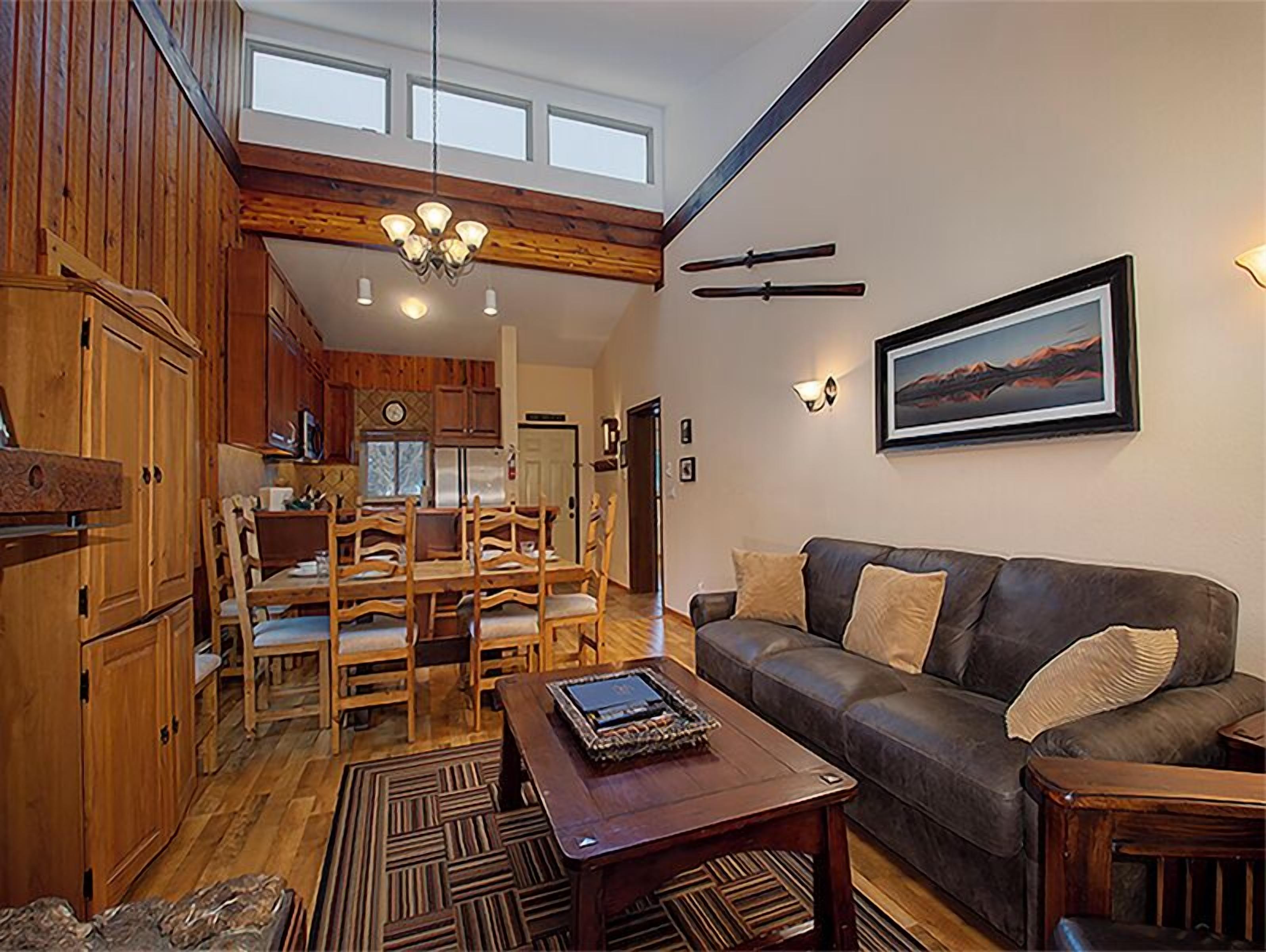A spacious living area with a dining set, a sofa, and a coffee table.