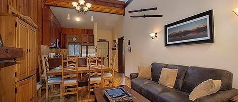A spacious living area with a dining set, a sofa, and a coffee table.