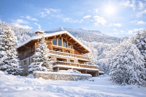 A wooden chalet with a stone foundation, surrounded by snow-covered trees and mountains. - SmartStay Chalet Ruitor Sainte-Foy-Tarentaise (Sainte-Foy-Tarentaise)