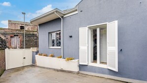 Ein modernes Gebäude mit grauer Fassade, weißen Fensterläden und einem verschlossenen Eingang.