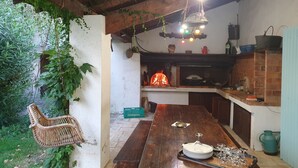 A rustic kitchen with a brick oven, wooden beams, and hanging lights. - Mas du Coustoubi between Avignon and St Remy. Swimming pool, Pétanque, BBQ (Châteaurenard)