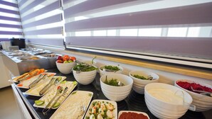 A buffet with various food items and utensils.