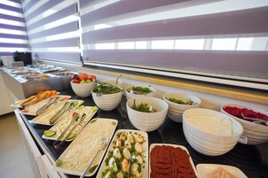 A buffet with various food items and utensils.