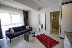 A modern living room with a sofa, coffee table, and a red rug. - elea premium stay (Denizli)