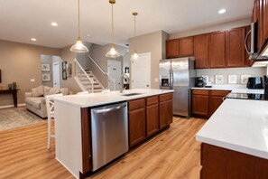 A modern kitchen with wooden cabinets, stainless steel appliances, and pendant lighting. - Spacious Home - Veranda Palms w/ Heated Pool & BBQ (Kissimmee)
