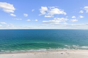 A beach with clear blue water and a sandy shore. - The Oasis At Orange Beach 2408 by Liquid Life (Orange Beach)